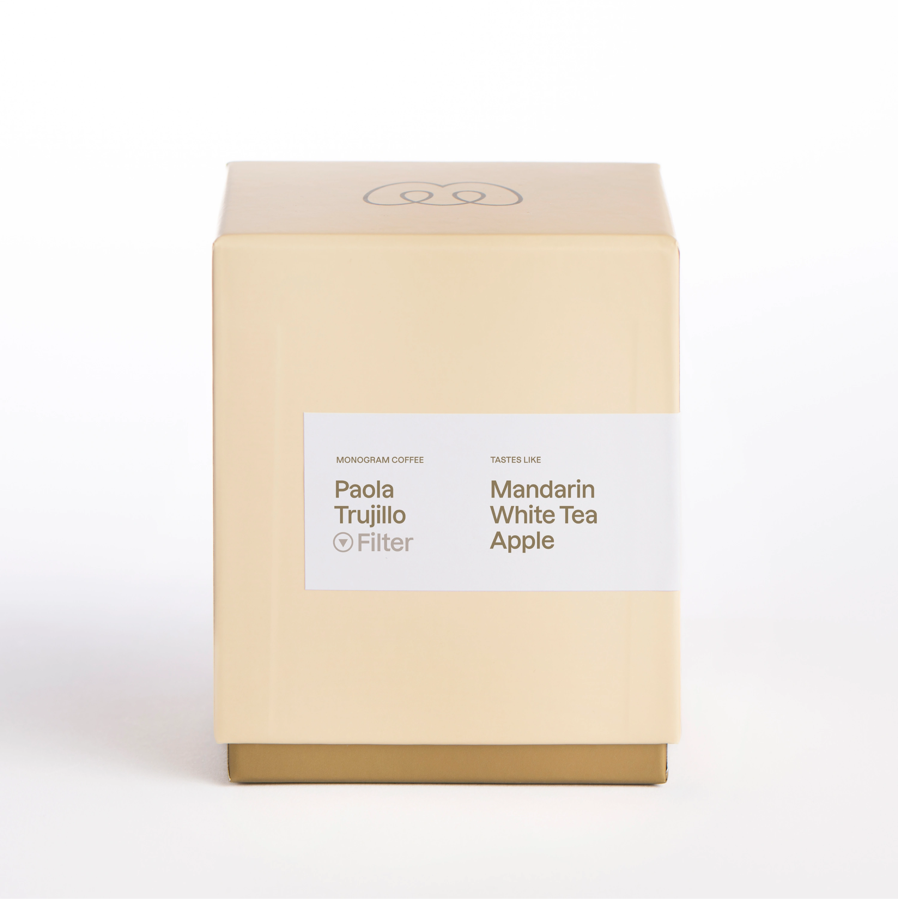 A premium cream and gold colored Monogram Coffee box for Paola Trujillo filter coffee, featuring a rare washed Wush Wush variety from Colombia with tasting notes of mandarin, white tea, and apple.