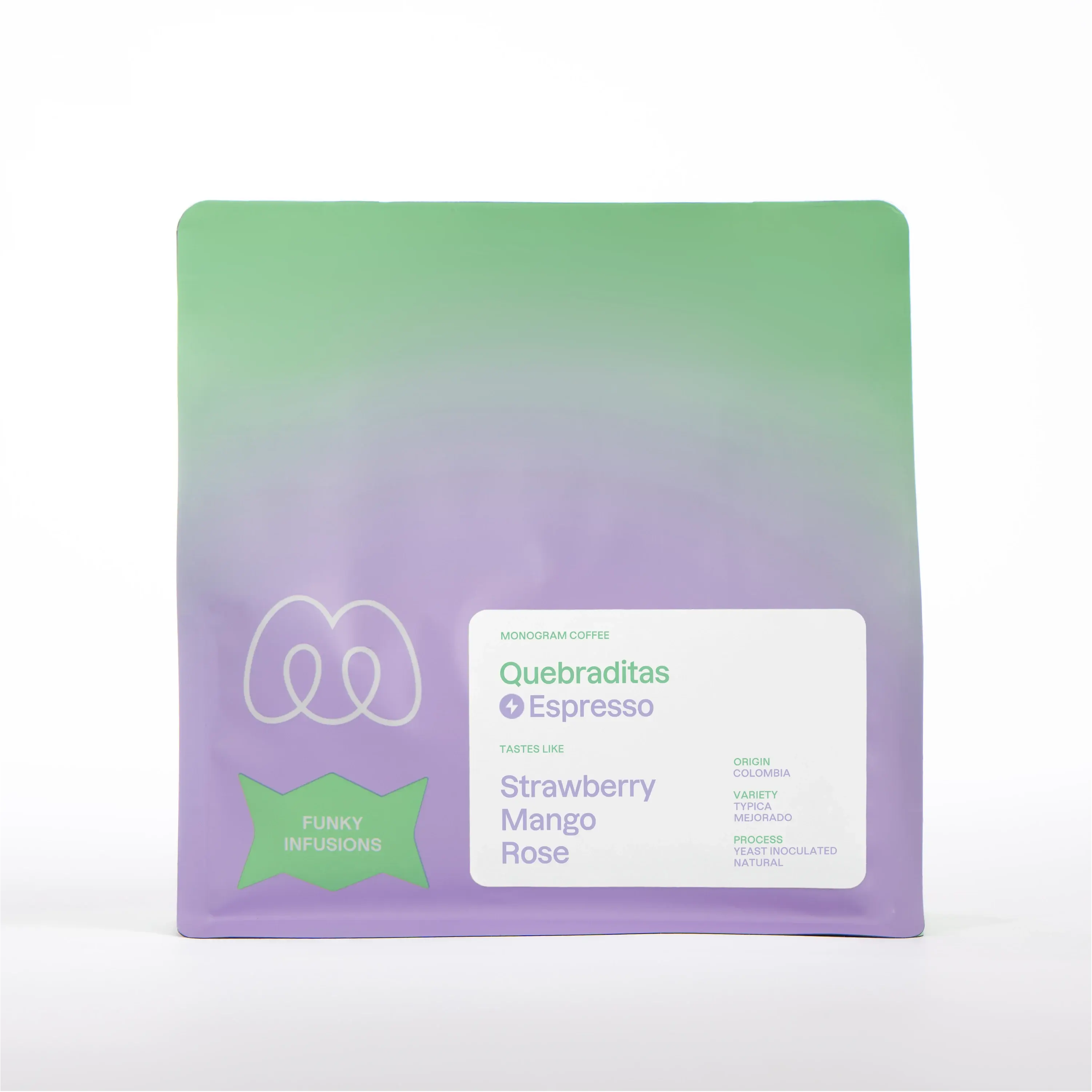 A purple and green gradient bag of Monogram Quebraditas espresso coffee, a yeast inoculated natural Typica Mejorado from Colombia with tasting notes of strawberry, mango, and rose.
