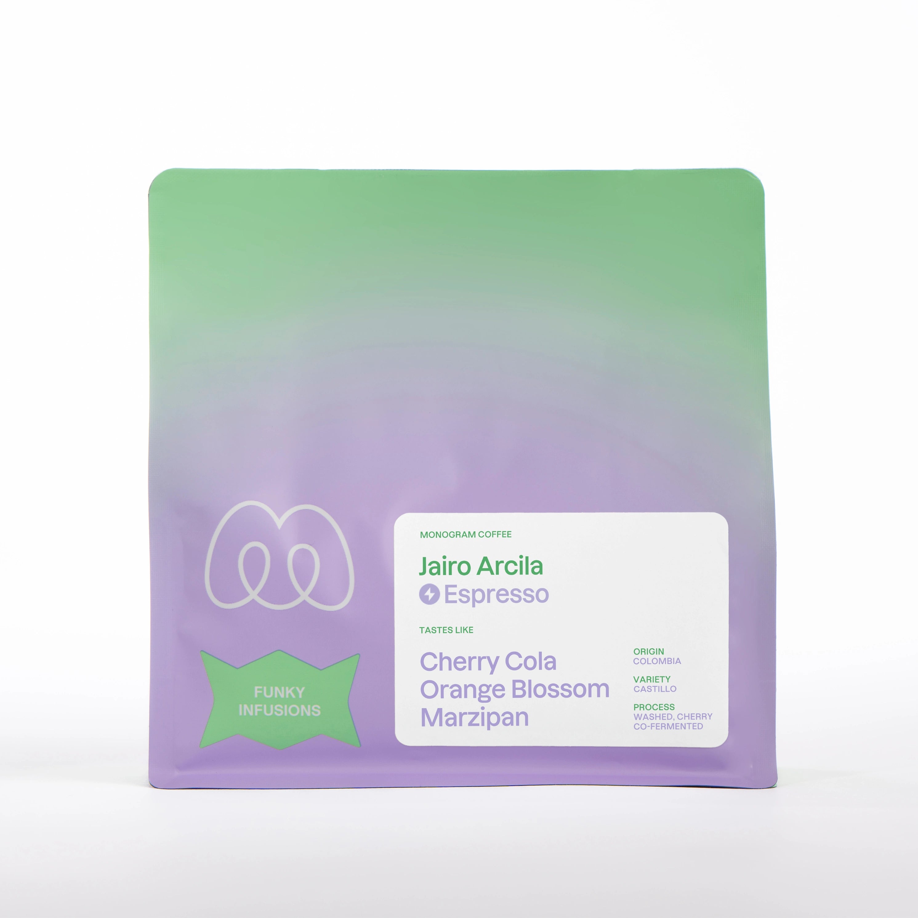 A purple and green gradient bag of Monogram Jairo Arcila espresso coffee, a washed cherry co-fermented Castillo variety from Colombia with tasting notes of cherry cola, orange blossom, and marzipan.