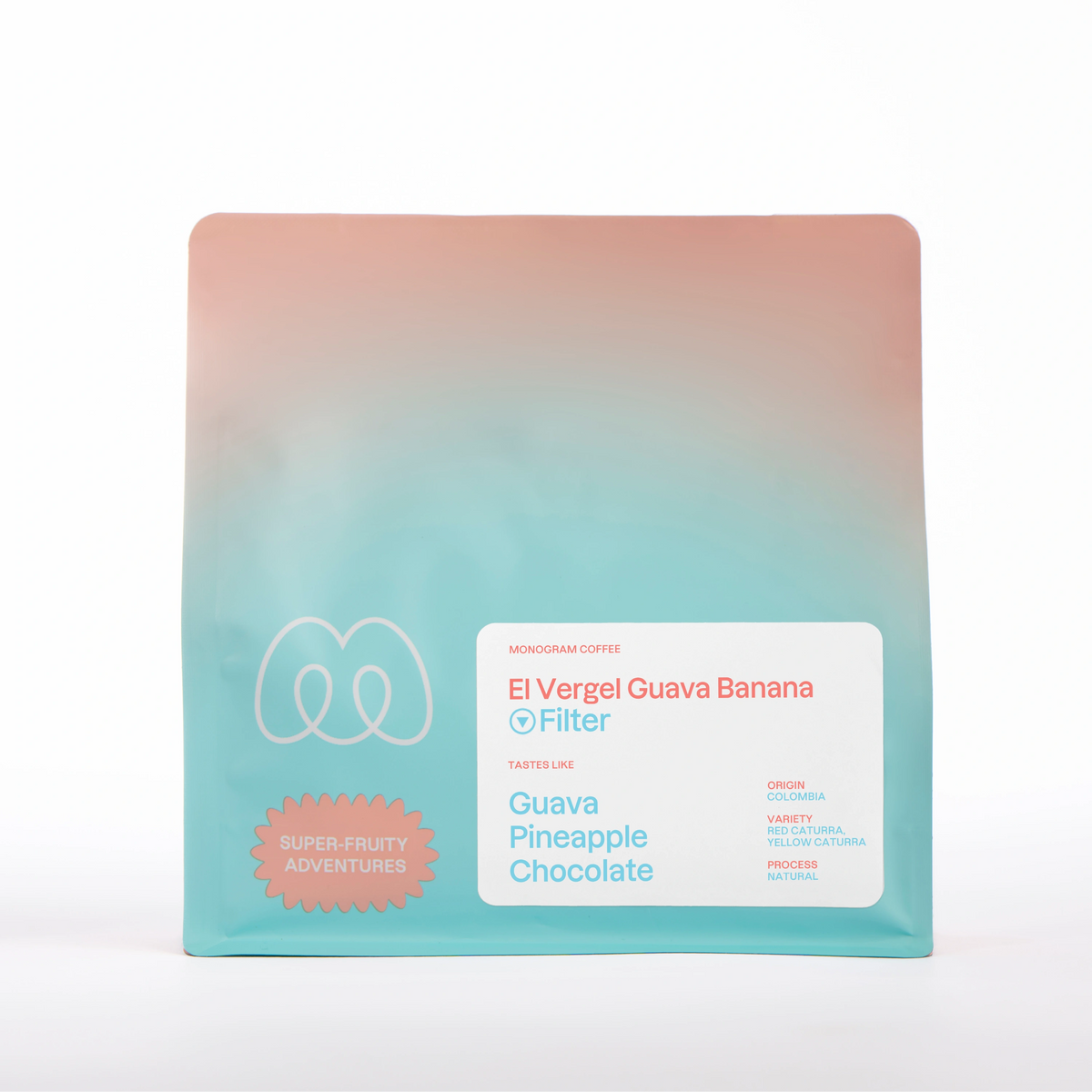 A peach and turquoise blue gradient bag of Monogram El Vergel Guava Banana filter coffee, a natural processed Red and Yellow Caturra variety from Colombia with a Super-Fruity Adventures label badge and tasting notes of guava, pineapple, and chocolate.
