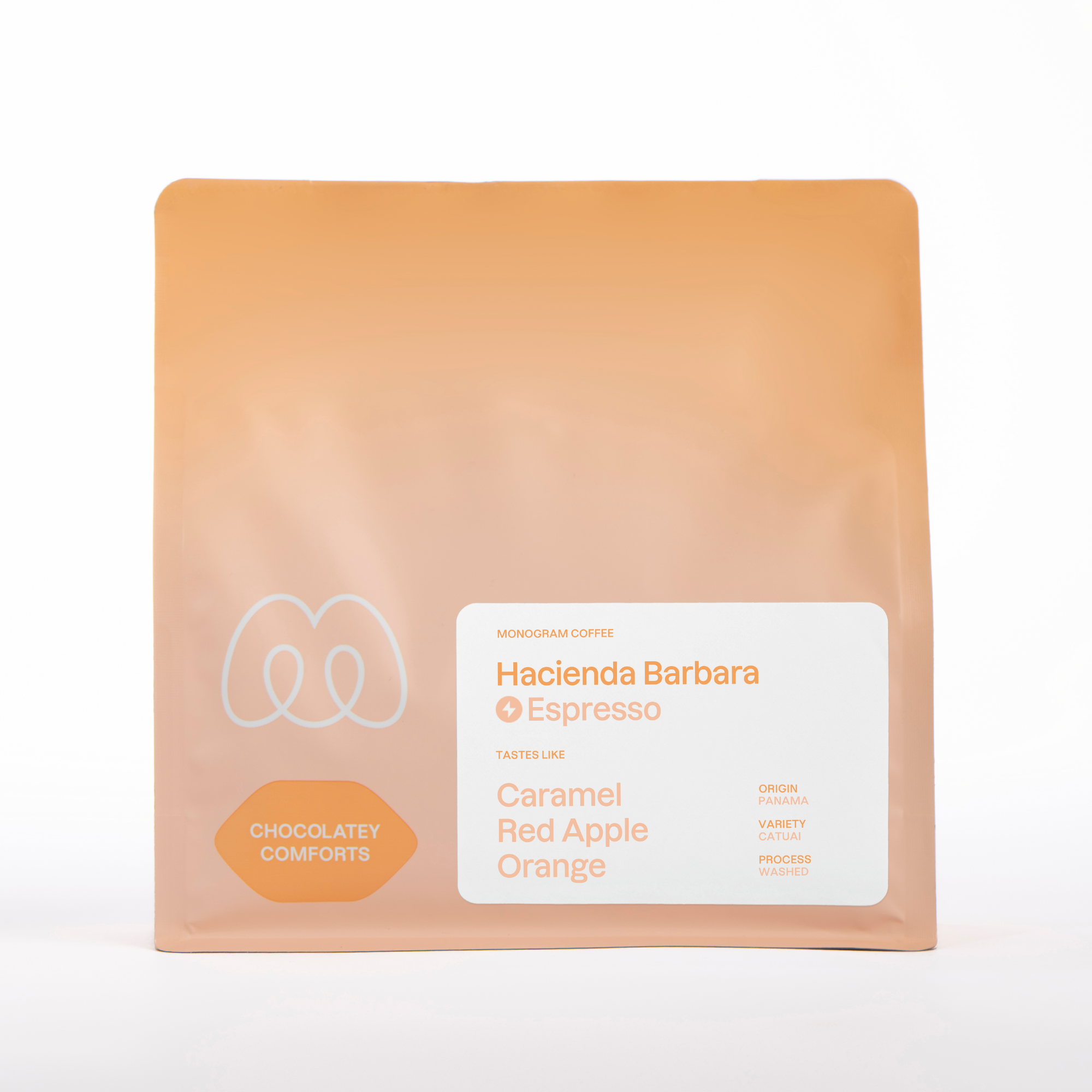 A peach-colored bag of Monogram Hacienda Barbara espresso coffee, a washed Catuai from Panama with tasting notes of caramel, orange, and red apple