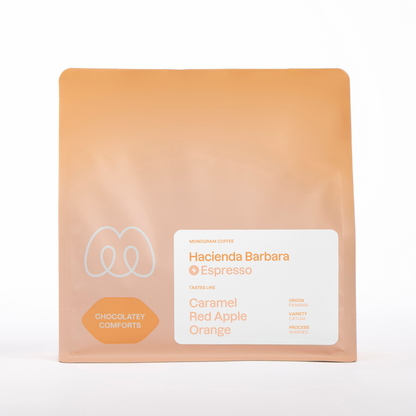 A peach-colored bag of Monogram Hacienda Barbara espresso coffee, a washed Catuai from Panama with tasting notes of caramel, orange, and red apple