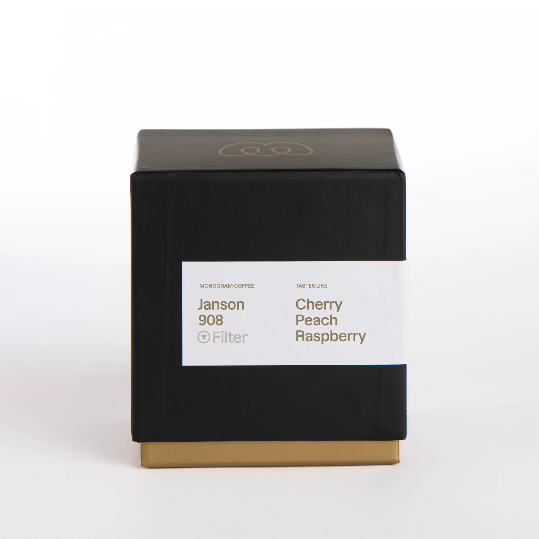 A premium black and gold box of Monogram Janson 908 filter coffee, a natural processed Gesha from Panama with tasting notes of cherry, peach, and raspberry.